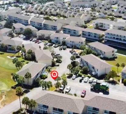 Aerial view of the vacation rental property nestled within a well-maintained residential community with landscaped grounds and convenient parking.