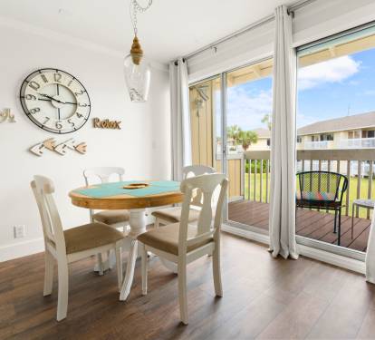Gather around your charming dining table where beach-themed décor and warm natural light create the perfect setting for morning coffee or evening meals.