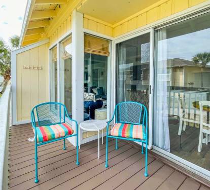 Your private deck awaits with colorful seating where you can sip morning coffee while watching palm trees sway in the coastal breeze.