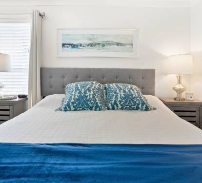 Sink into coastal comfort in your serene bedroom, where ocean-inspired blues and soft lighting create the perfect retreat for restful nights.