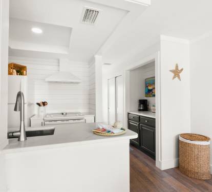 Your coastal-inspired kitchen features sleek countertops and modern appliances, perfect for preparing memorable meals during your stay.