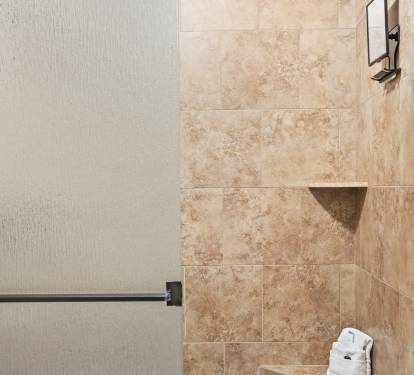 Walk-in tiled shower with updated finishes—perfect for rinsing off after a beach day.