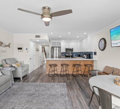 Relax in your open-concept haven with coastal décor, modern kitchen island seating, and cozy living space perfect for gathering.