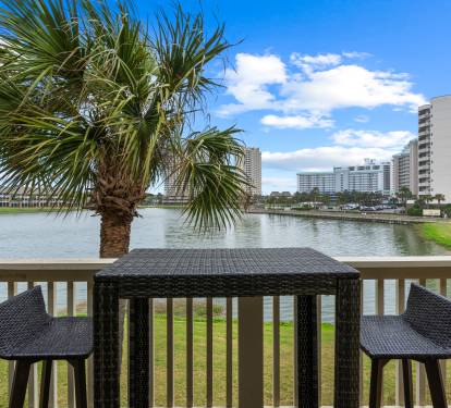 Sip your morning coffee at this waterfront bistro table, where peaceful lake views and swaying palms create the perfect backdrop for relaxation.