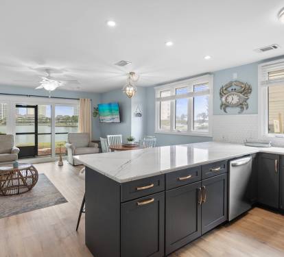 Spacious open layout with quartz countertops, navy cabinets, and lake views from the kitchen—perfect for entertaining and relaxing in style.