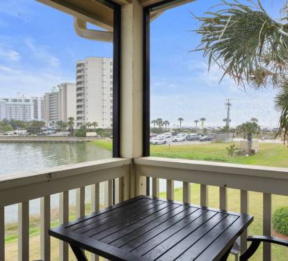 Enjoy serene lake and partial Gulf views from this cozy screened balcony, complete with a bistro table—ideal for relaxing in the coastal breeze.