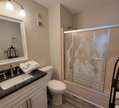 Primary bathroom with a full tub/shower combo—perfect for relaxing after a day at the beach.
