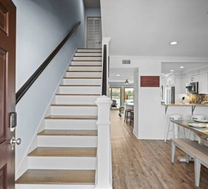 Bright entryway featuring LVP wood floors, and an open layout leading to a modern kitchen and living area with lake views. Clean, airy, and inviting.