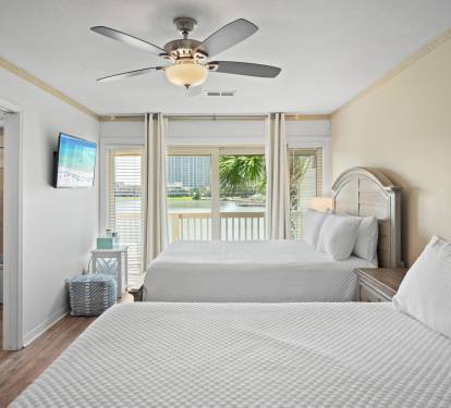 Sliding glass doors open to a balcony with peaceful lake views and natural light.
