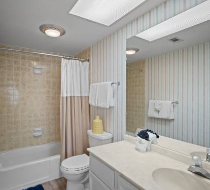 Full bathroom with a tub/shower combo. Soft lighting and neutral tones create a clean, classic look.