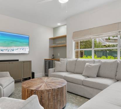 Relax in this cozy, coastal living room with plush seating, natural textures, and a built-in wine bar.