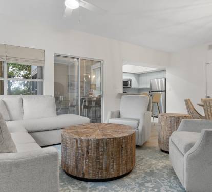 Comfort meets coastal style in this open-concept living area with plush seating and rustic wood accents.