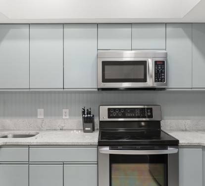 Sleek and functional, this kitchen boasts wood cabinetry, granite counters, and stainless-steel appliances.