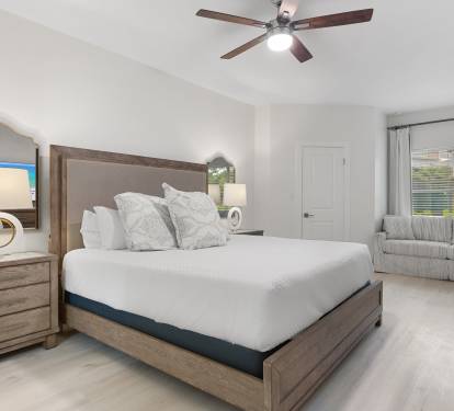 This serene bedroom offers a king bed, queen-size pullout sofa, warm wood tones, and soft coastal elegance.