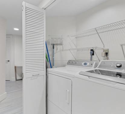 Tucked behind louvered doors, this laundry nook offers a full-size washer and dryer for added convenience.