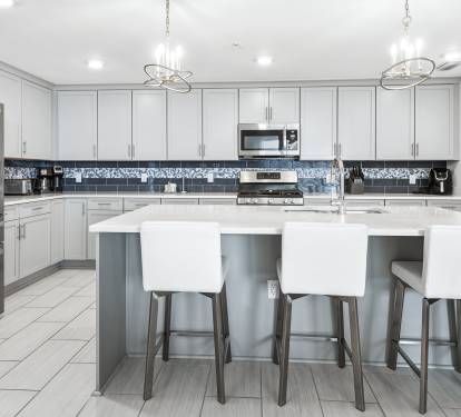 Your gourmet kitchen awaits with gleaming quartz countertops, modern appliances, and stylish island seating for memorable meal prep and casual dining.