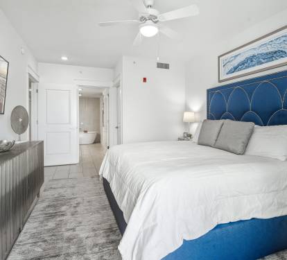 Drift off in your coastal-inspired bedroom with ocean artwork and crisp linens beneath a gentle ceiling fan.