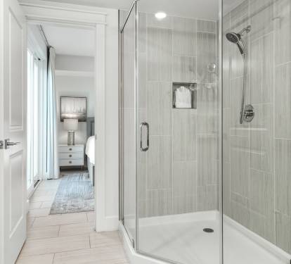 Step into your private spa-like shower with elegant glass doors and soothing gray tile that creates the perfect retreat after long days of exploring.
