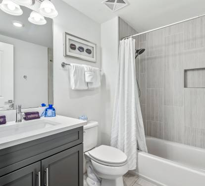 Unwind in your pristine bathroom featuring elegant tiling, modern fixtures, and thoughtful amenities for your comfort.