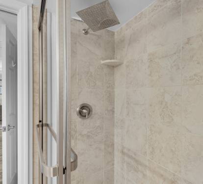 Step into your private rainfall shower with elegant tile work and modern fixtures, perfect for refreshing after a day of adventure.
