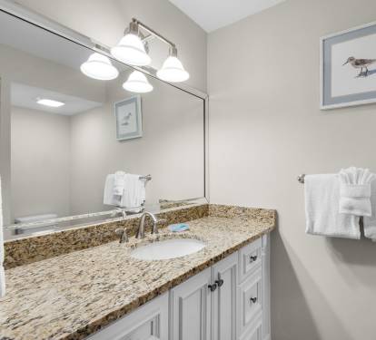 Bathroom 2 with bright vanity lighting, and plush white towels waiting just for you. Thoughtful coastal touches create a calming retreat after your day exploring.