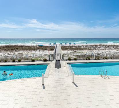 Expansive beachfront pool deck with direct beach access and stunning Gulf Coast views creates the perfect vacation setting.