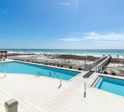 Beachfront pools feature crystal-clear water with direct access to pristine white sand and turquoise Gulf waters.