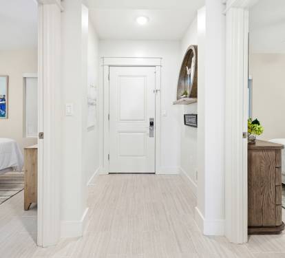 Step into your bright, modern hallway connecting two comfortable bedrooms with clean white walls and warm wood finishes throughout.