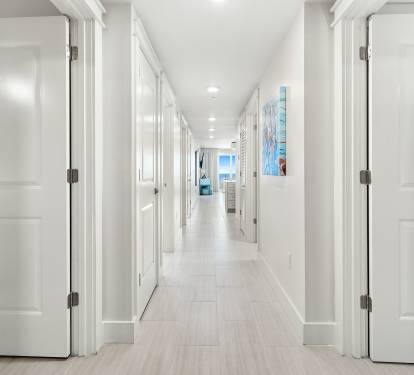 Step into your bright, elegant hallway with gleaming floors and modern touches that lead to your comfortable living spaces.