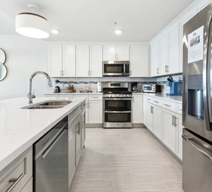 Your sleek kitchen features stainless steel appliances, quartz countertops, and everything needed for culinary adventures.