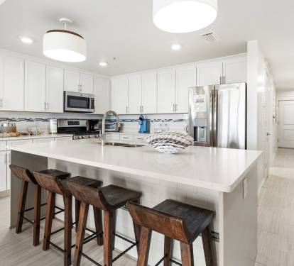 Your sleek kitchen features modern appliances, quartz counters, and a spacious island for cooking and casual dining together.