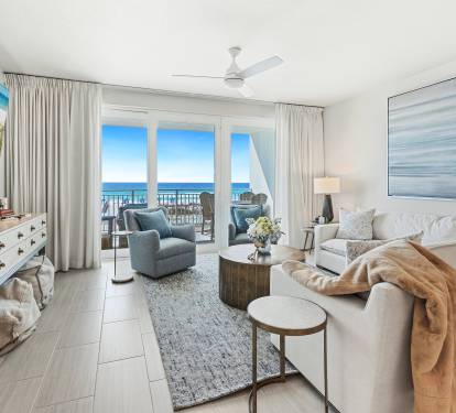 Unwind in your bright living room with stunning ocean views through floor-to-ceiling windows and cozy seating perfect for relaxation.