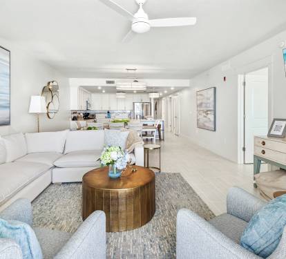 Sink into plush seating surrounded by coastal blues and modern comfort, where your open-concept space flows seamlessly into a bright kitchen.