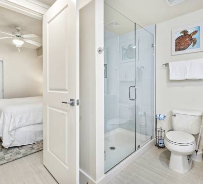 Your private bathroom features a glass walk-in shower, modern fixtures, and fresh towels, with your comfortable bedroom just steps away.