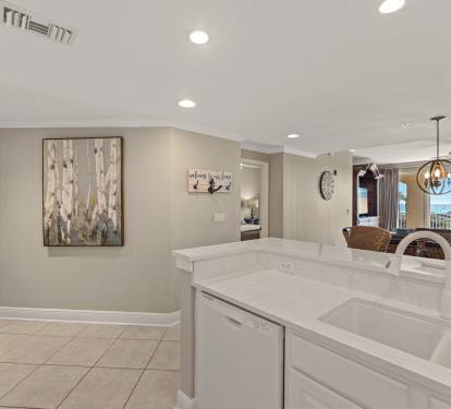 The modern kitchen flows seamlessly into the dining area, featuring gleaming quartz counters and sleek appliances for memorable meals together.