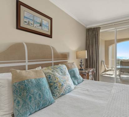 The elegant Primary bedroom features coastal colors and a private balcony where you'll wake to beautiful views each morning.