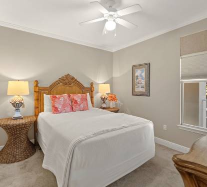 Rest peacefully in the cozy bedroom featuring crisp linens, warm wicker accents, and gentle ceiling fan breezes.