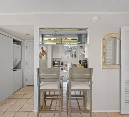 The breakfast bar offers additional seating for casual meals, snacks, or evening drinks, with an open pass-through design connecting the kitchen and living area for an easy, relaxed coastal feel.