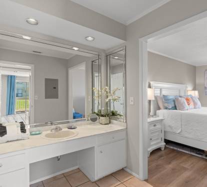 The spacious dressing area offers a large vanity, bright lighting, and plenty of counter space, creating a comfortable spot to get ready while remaining conveniently connected to the primary bedroom.