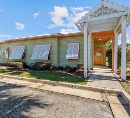 Charming vacation rental with tropical landscaping and welcoming covered entrance in a peaceful residential setting.