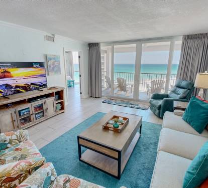 Unwind in your oceanfront living room where turquoise accents mirror the sea views through floor-to-ceiling windows onto your private balcony.