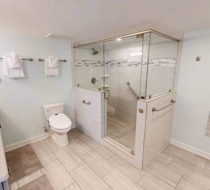 Step into your spacious, accessible bathroom featuring a walk-in shower with grab bars, premium fixtures, and thoughtful design for comfort and safety.
