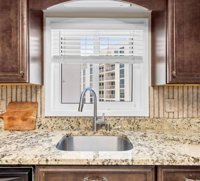 Prepare your favorite meals in this elegant kitchen featuring granite countertops, modern appliances, and a lovely window view.