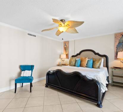 Drift off to sleep in this elegant bedroom where tropical ceiling fans keep you cool and vibrant artwork creates a serene escape.
