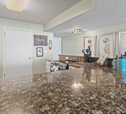 You'll love cooking in this spacious kitchen with gleaming granite counters, modern appliances, and charming botanical artwork creating a welcoming culinary haven.