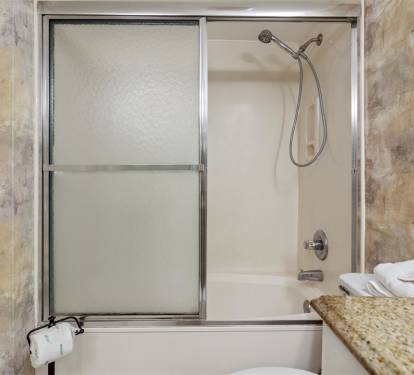 Your elegant bathroom features a spacious tub-shower combo with polished fixtures and fresh towels ready for your relaxing soak.