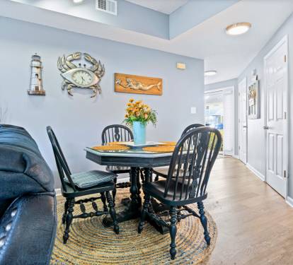 Gather around this charming dining table adorned with coastal touches, where you'll share meals surrounded by nautical art and warm lighting.