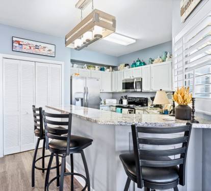 Your fully equipped kitchen awaits with granite countertops and breakfast bar seating for casual coastal dining.