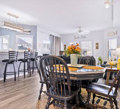Gather around your elegant dining table for memorable meals, with the open kitchen perfect for cooking together and coastal decor creating a relaxing atmosphere.
