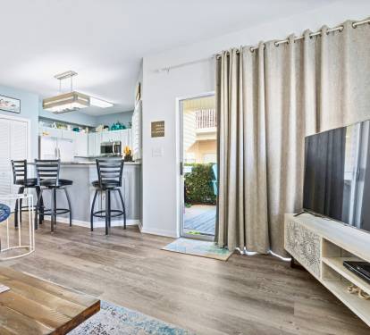 Relax in your bright open-plan living space with modern kitchen, cozy seating, and sliding door access to your private outdoor area.